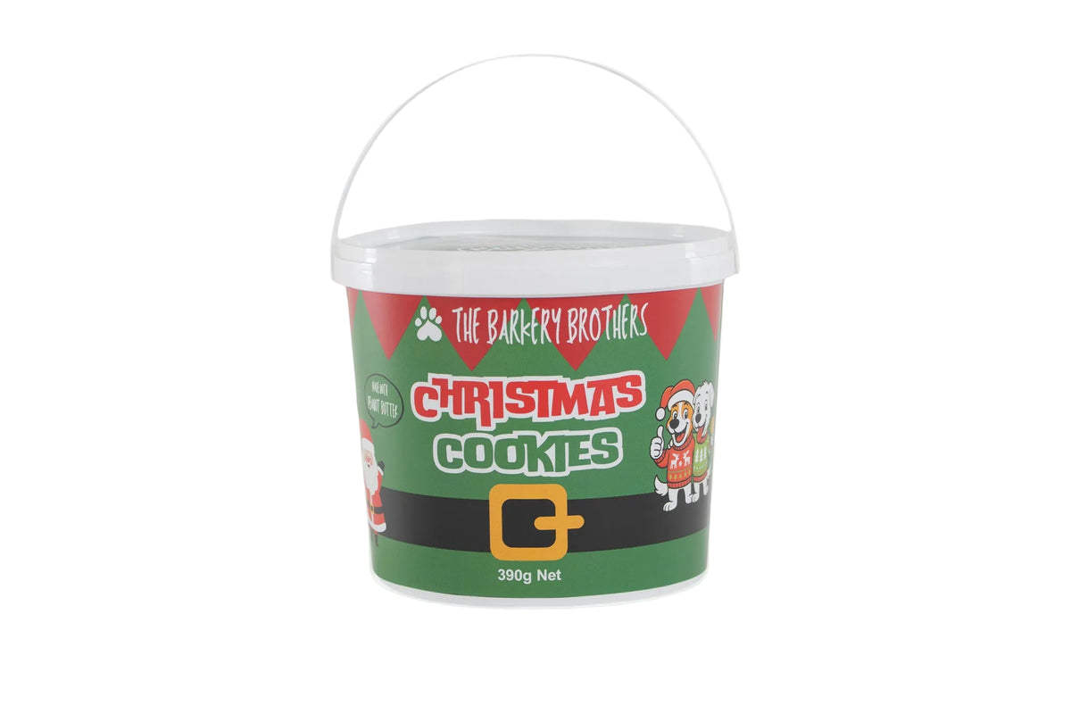 A white plastic bucket of 'The Barkery Brothers' Christmas Cookies, featuring a festive green and red label with a black belt graphic and a white handle, set against a plain white background.