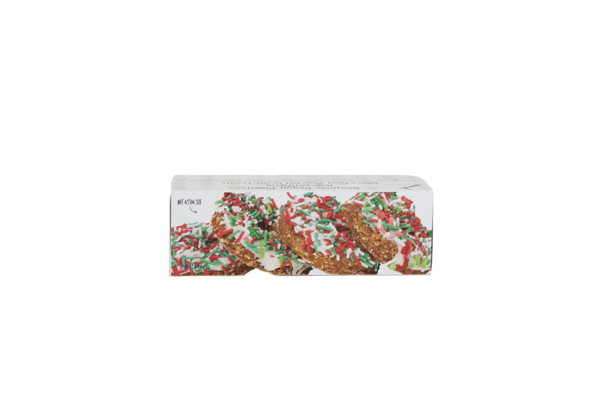 A rectangular box of holiday-themed donuts with white icing and red and green sprinkles, shown on a plain white background.
