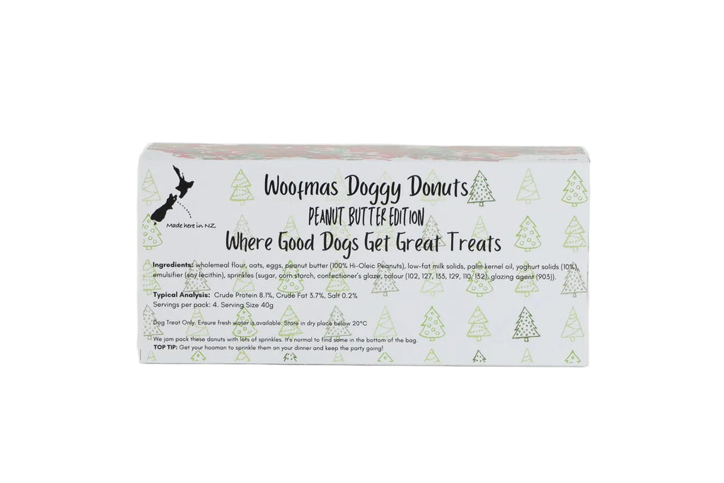 A rectangular box of Woofmas Doggy Donuts Peanut Butter Edition dog treats, featuring a white background with light green pine tree illustrations and black text, set against a plain white background.