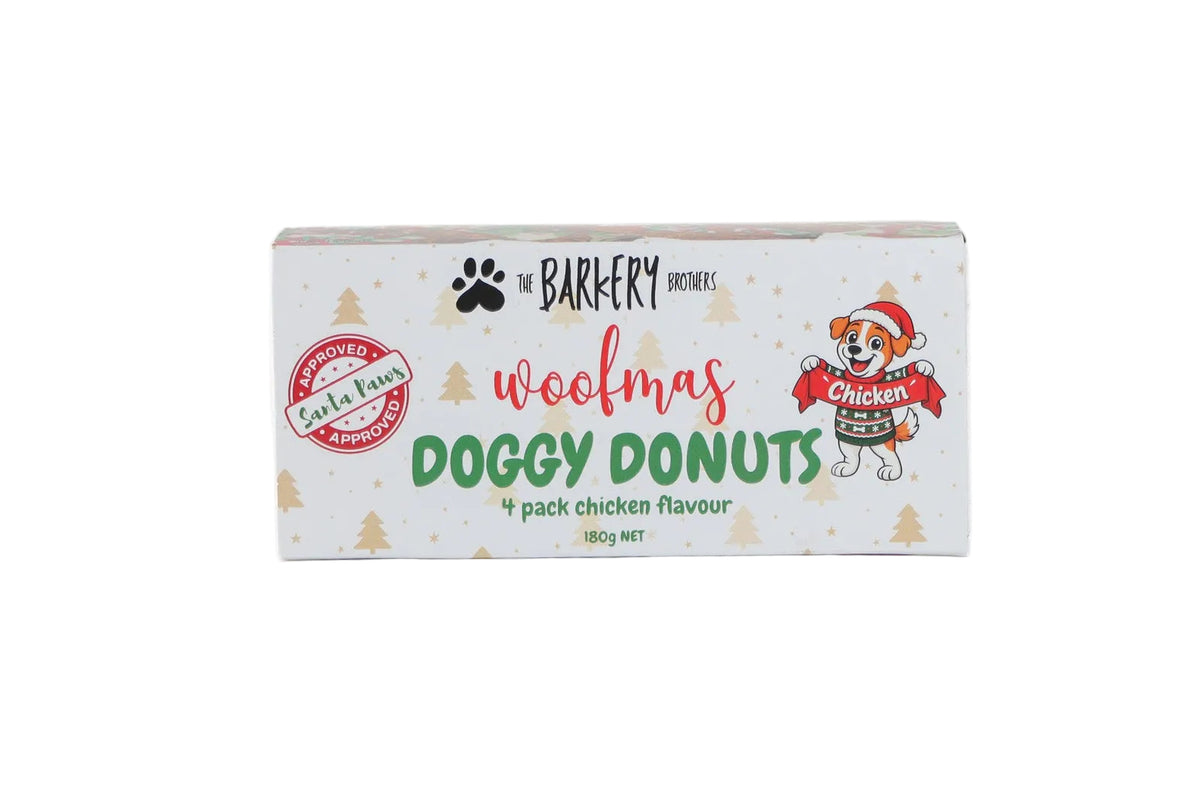 A rectangular box of 'woofmas DOGGY DONUTS' dog treats by 'The Barkery Brothers' on a plain white background.